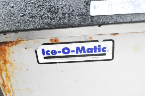 Ice-O-Matic commercial ice bin, visible rust and wear, labeled with "Ice-O-Matic" logo, metal exterior.