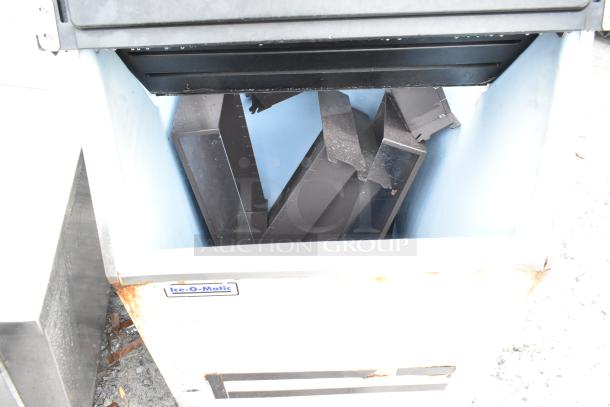 Ice-O-Matic commercial ice bin with visible rust spots and label, open showing internal components.
