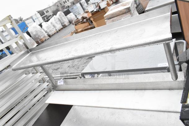 Commercial kitchen table with over shelf, undershelf, bay, and doors. Stainless steel, good condition, suited for heavy-duty use.