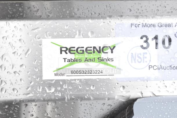 alt="Regency 600S32323224 label on stainless steel commercial 3 bay sink with dual drain boards, new condition."