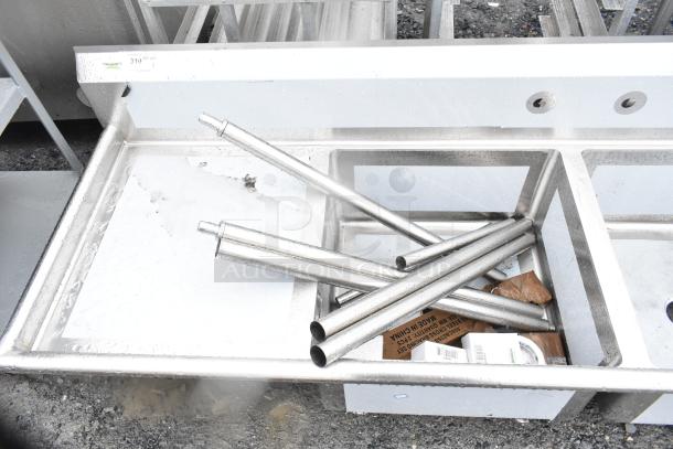 Brand new Regency 600S32323224 3 bay sink with dual drain boards, visible scratches and dents, stainless steel construction.