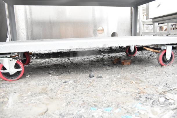 Brand new Lavex 48" x 24" x 35" steel utility cart, three shelves, fully welded, visible scratches and dents, with red wheels.