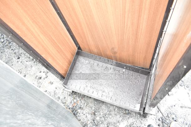 Merchandising rack on casters with wood panel sides, metal base, and visible surface wear, suitable for retail display.