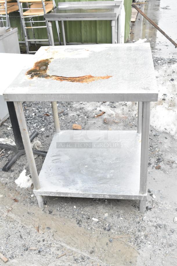 Commercial table with metal under shelf, visible rust damage on top surface, suitable for industrial use, weathered condition.