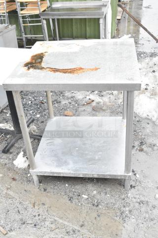 Commercial table with metal under shelf, visible rust damage on top surface, suitable for industrial use, weathered condition.