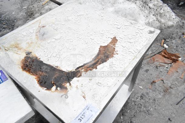 Commercial table with metal under shelf; weathered surface and rust stains; auction label present.