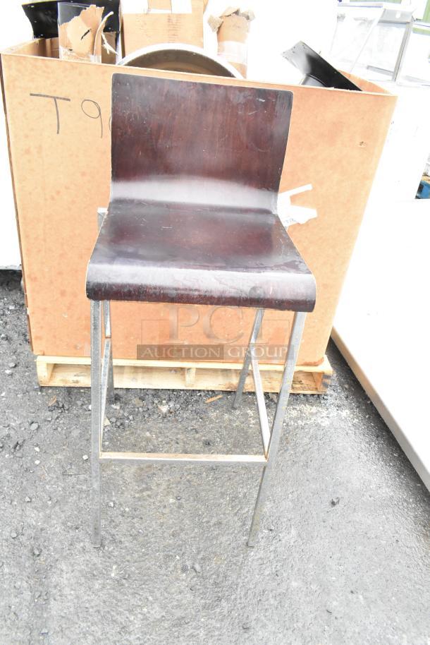 Bar height chair with wooden seat and chrome finish frame, in fair condition. Part of a set of 19 chairs.