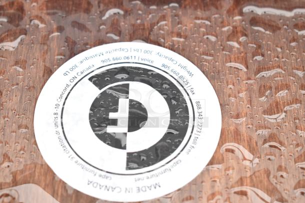 Wooden seat detail with raindrop pattern highlighting the grain. Visible sticker reads: "Made in Canada" and manufacturer details.