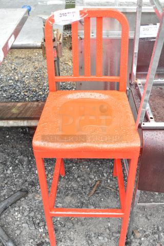 Red metal bar height chair with a slatted back and seat. Wet surface indicates outdoor storage. Auction tag visible.