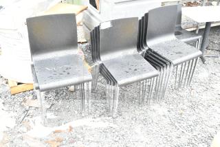20 dining height chairs with black seats and chrome finish frames, slightly wet, showing outdoor placement.