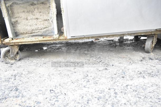 2017 Traulsen TS048HT commercial pizza prep table. Visible wear, insulation exposed. On commercial casters. 115 Volts, 1 Phase.