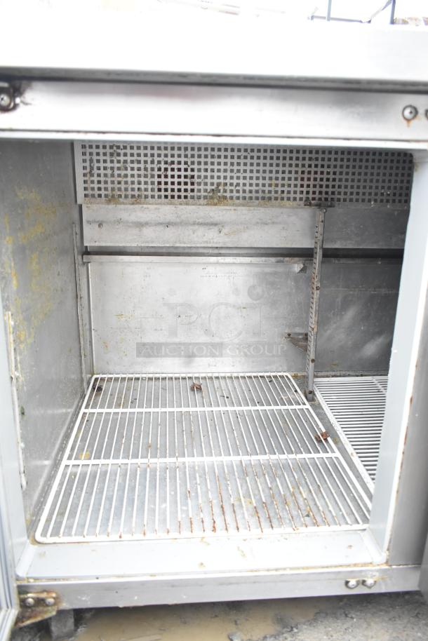 Continental CRA68 undercounter cooler, 3 doors, visible interior shelving, signs of wear, powered by 115 volts, 1 phase.