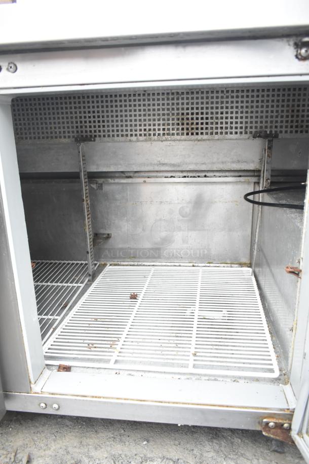 Continental CRA68 3 Door Undercounter Cooler, 115V, 1 Phase, showing interior with wire shelving and minor wear.