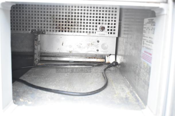 Continental CRA68 commercial undercounter cooler interior with visible adjustable temperature dial and power cord.