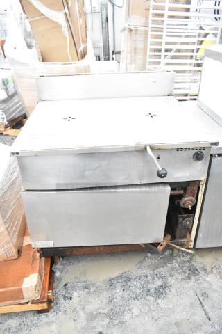 Commercial floor-style braising pan in used condition. Features a stainless steel exterior, manual controls, and visible wear.