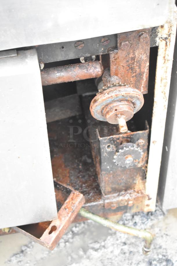 Rusty commercial floor style braising pan with visible mechanical components. Showing signs of wear and corrosion.