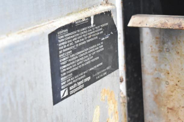 Commercial braising pan label shows instructions from South Bend Range Corporation, model P/N 116-1390. Some wear visible.