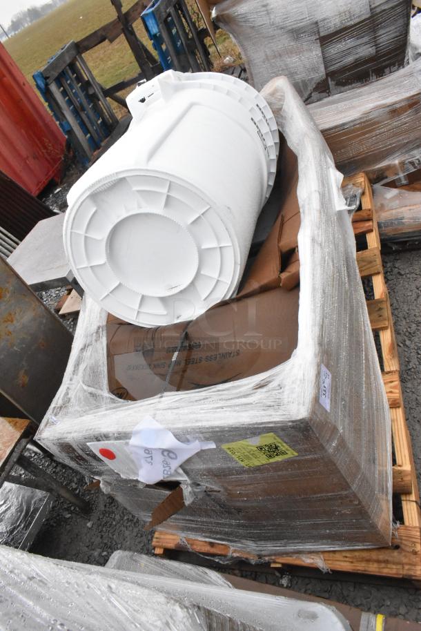 Four brand new scratch and dent items, including a pump motor and sinks, wrapped on a pallet for auction.