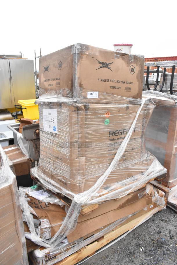 Stack of brand new scratch and dent items, including a Regency stainless steel mop sink, in original packaging.