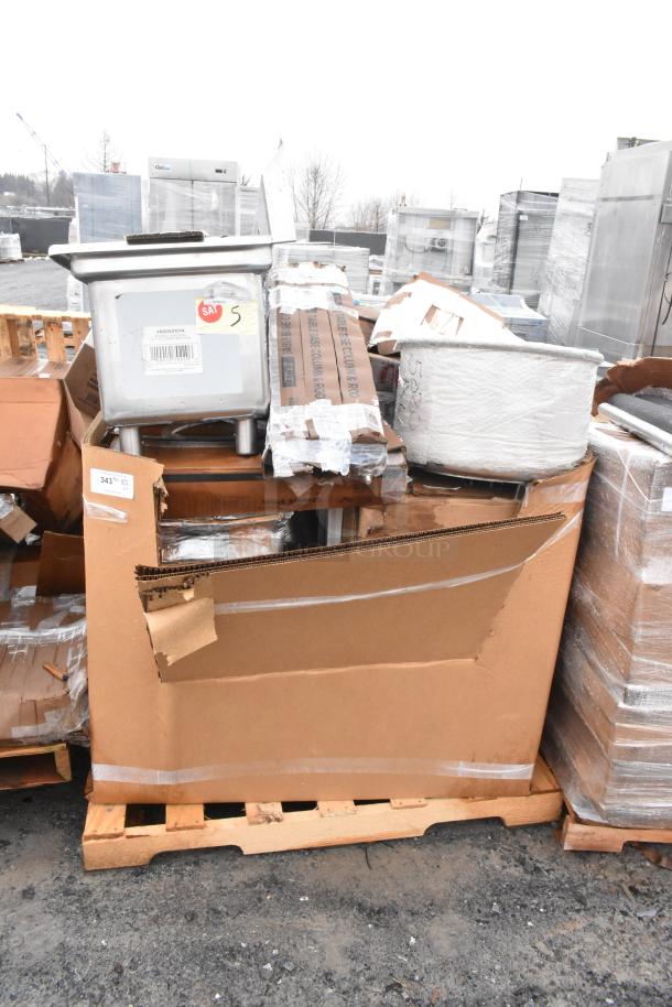 15 new scratch and dent items on pallets, including a stainless steel sink and grease trap; visible packaging labels.