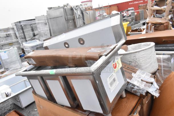15 brand new scratch and dent items, including a stainless steel sink and grease trap, some with sale tags.