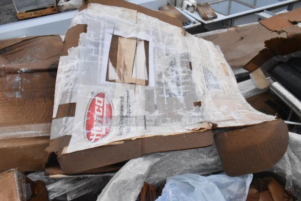 15 brand new scratch and dent items, including a sink and grease trap, packaged in cardboard. Some wear visible.