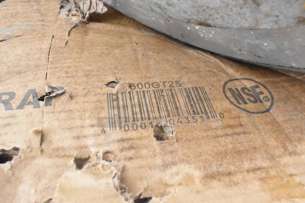 Cardboard with barcode 600GT25 and NSF mark, indicating a scratch and dent item, possibly a sink or grease trap.