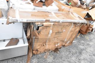 Regency stainless steel items in original damaged packaging; includes adjustable work table undershelf and dish cabinet with midshelf.