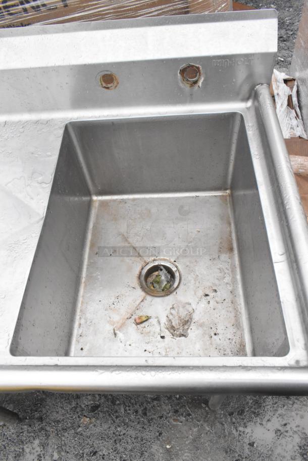 Win-holt commercial single bay sink with left side drain board, stainless steel, used condition, visible debris in basin.