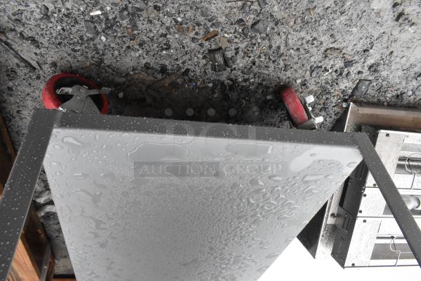 Lavex 48"x24"x35" steel utility cart, brand new, three shelves, fully welded, visible surface moisture, red caster wheels.