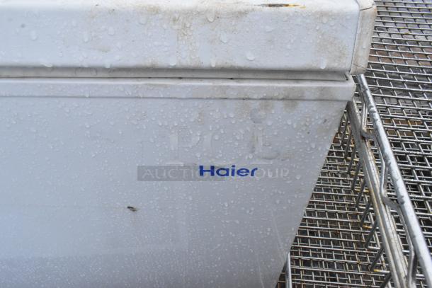 Two Haier HF50CM23NW/HF71CL53NW chest freezers, 115 volts, 1 phase, slight wear visible, Haier logo seen.