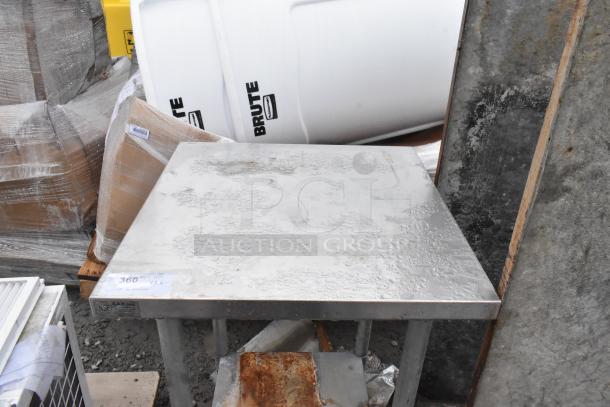 Stainless steel commercial table with an under shelf, surface wear visible. Marked with auction number and NSF label.