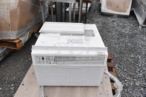 Keystone KSTAW25C window air conditioner on pallet. Features control panel, visible warning labels. 208/230V, 1 Phase.