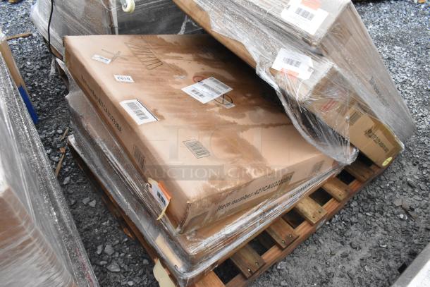 Three brand new items in boxes labeled "Outdoor Tables," wrapped in plastic on a pallet. Some boxes show signs of water damage.