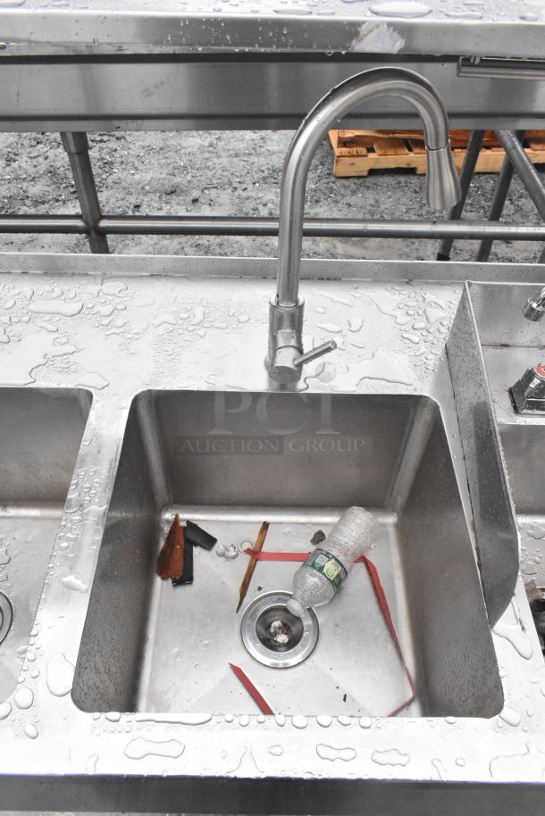 Commercial prep station with three-bay sink, single bay hand sink, under shelves, over shelf; stainless steel surface, wet condition.
