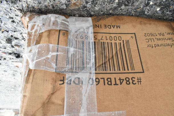 Damaged cardboard with clear tape, showing barcode and partial markings. Product details are not visible.