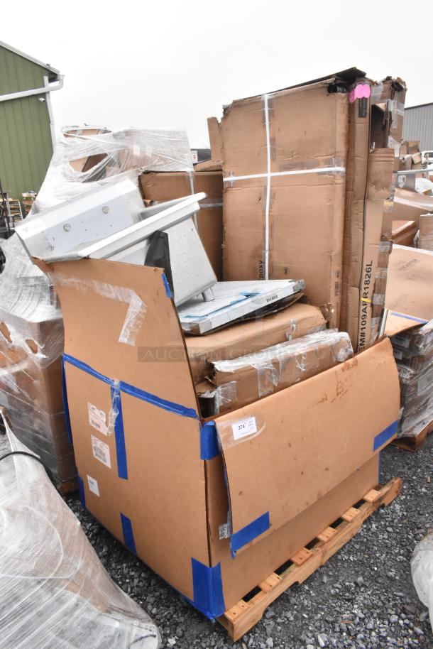 Lot of 10 new scratch and dent items on pallets, including a sink and work table, in cardboard packaging with visible labels.