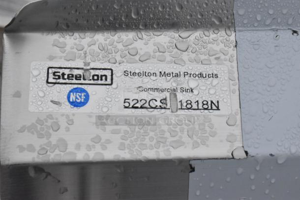Steelton Metal Products commercial sink label, model 522CS-1818N, with NSF certification, on metal surface.