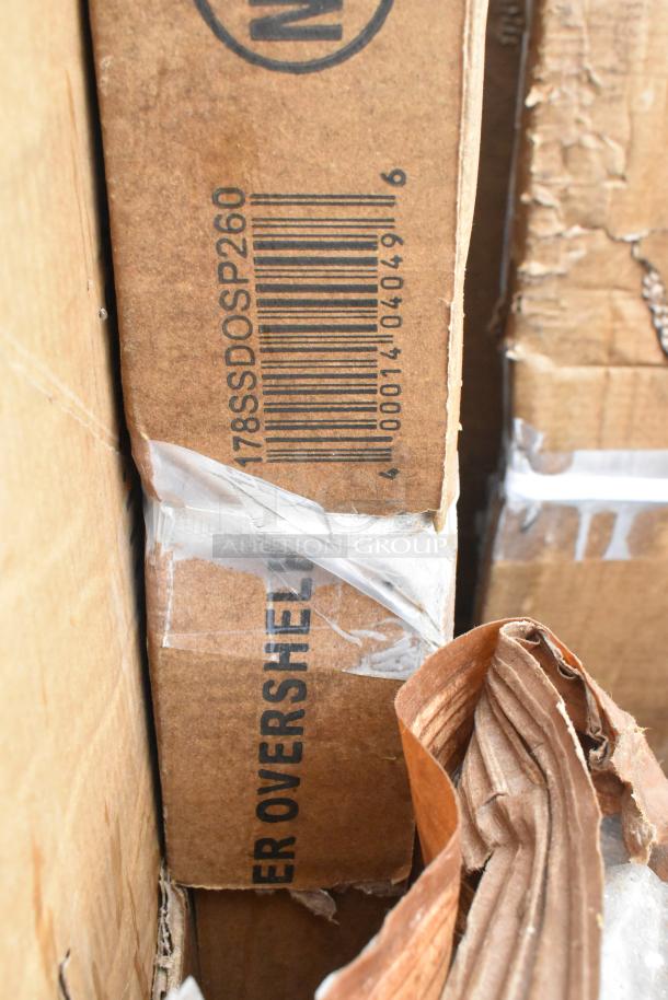 Boxes labeled "Overshelving" with barcode, showing wear. Contains 10 new scratch and dent items like a sink and work table.