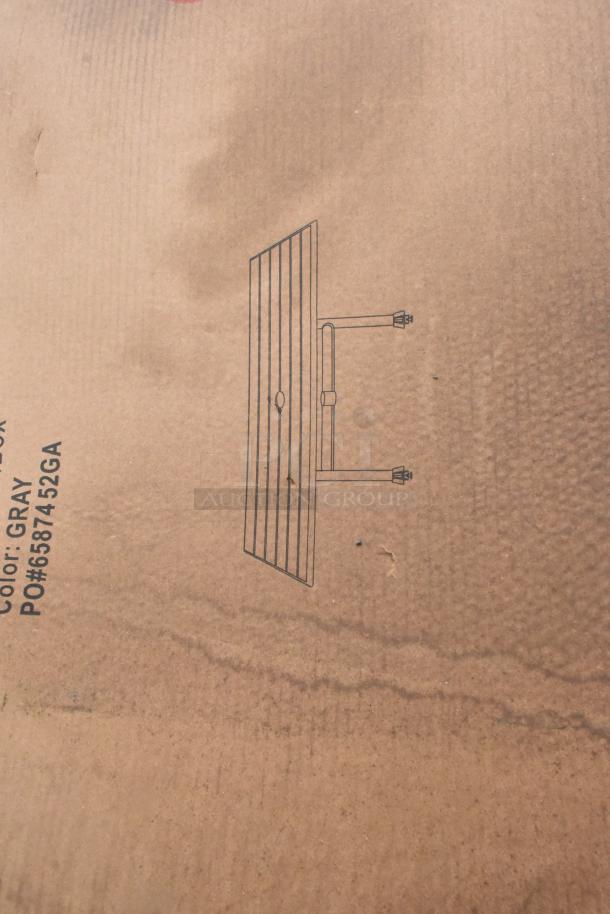 Cardboard packaging with sketch of an outdoor table, labeled "Color: Gray, PO#6587452GA." Contains new scratch and dent items.