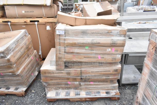 15 brand new scratch and dent items including outdoor tables on pallets, wrapped in plastic. Item numbers visible on boxes.