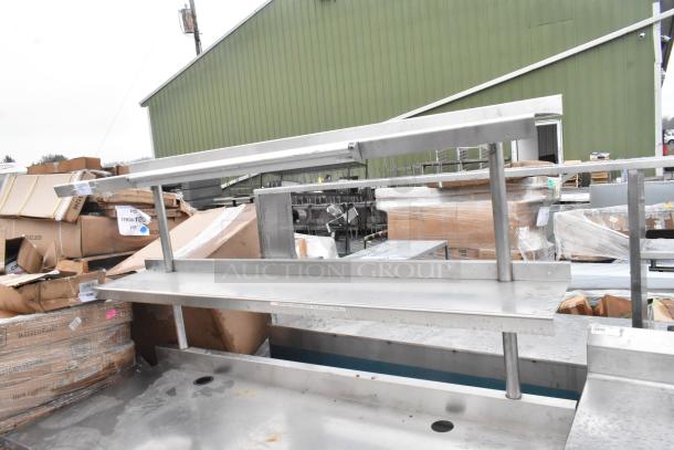 Commercial table with two-tier over shelf and drawer, stainless steel, industrial setting, fair condition.
