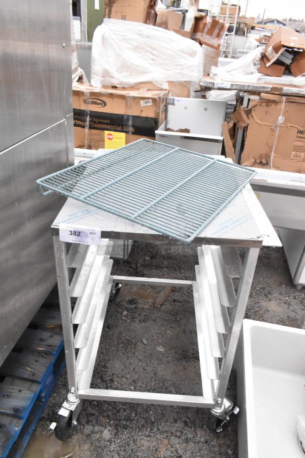 Commercial pan transport rack with multiple shelves on heavy-duty casters. Metal construction; auction tag visible. Excellent condition.