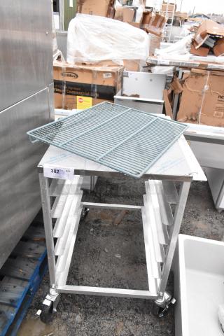 Commercial pan transport rack with multiple shelves on heavy-duty casters. Metal construction; auction tag visible. Excellent condition.