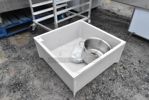 Poly mop sink, used condition, with visible scratches. Includes metal strainer and pot. Ideal for commercial cleaning.
