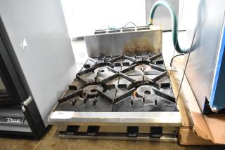 BT60-4N Commercial Gas 4 Burner Range, model BT60-4N, showing some wear with visible labels on control knobs.