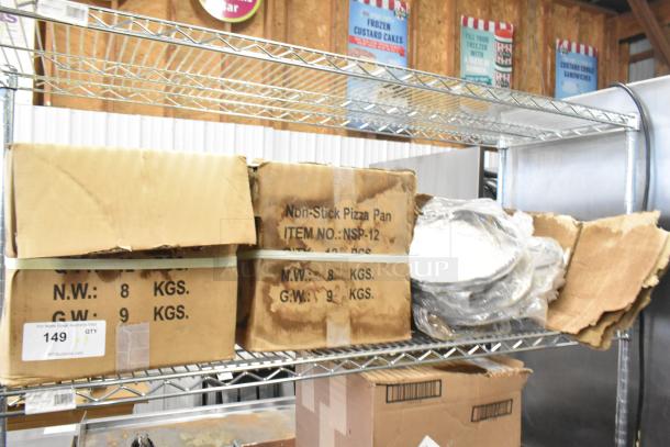 Three new boxes of NSP-12 non-stick pizza pans on metal shelf. Each box: 12 pans, 8kg net weight. Pans visible in open box.
