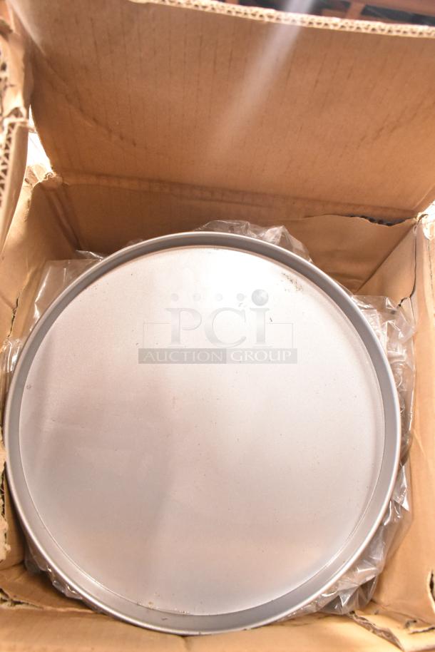 Three brand new NSP-12 non-stick pizza pans in original box, pristine condition.