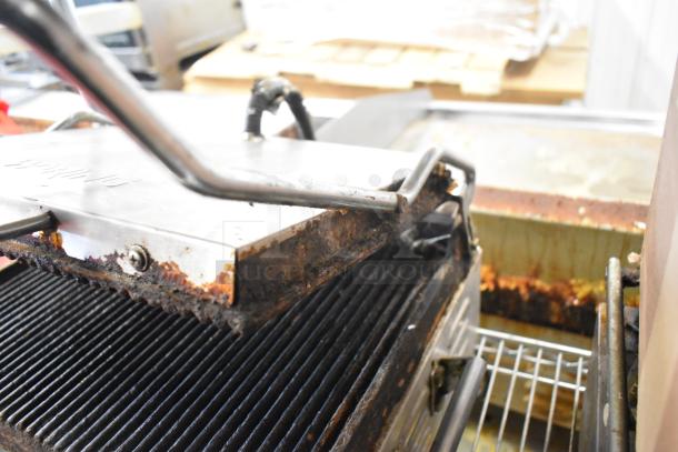 Waring WPG250 countertop panini press, 120 volts, visible wear, and residue on grill plates, suitable for commercial use.