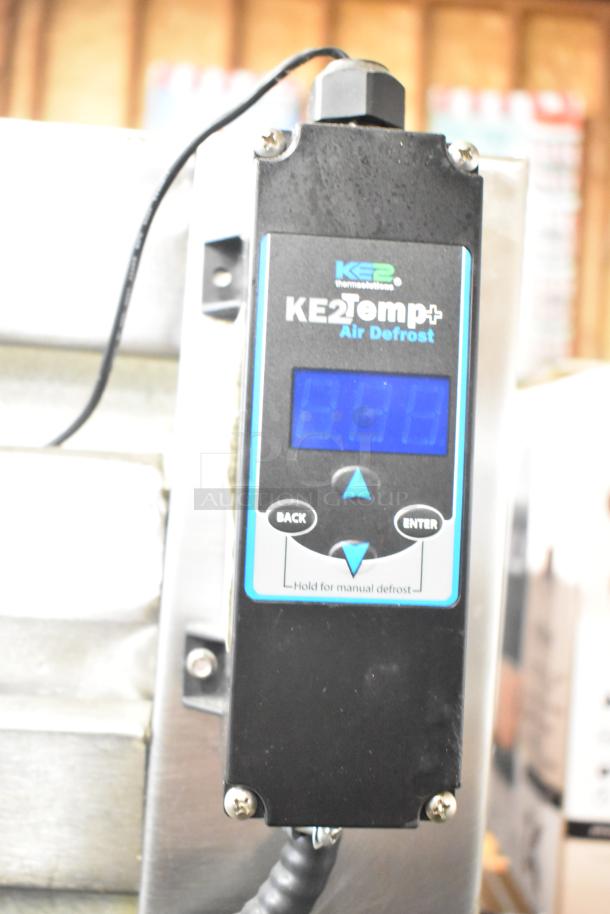 Alt text: Traulsen 4 half-size door reach-in refrigerator with KE2 Temp+ Air Defrost control, mounted on commercial casters.